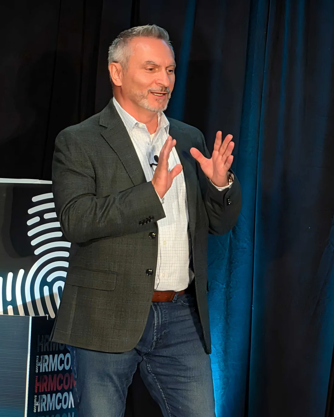 A speaker presenting on the HRMCon 2026 stage in Austin