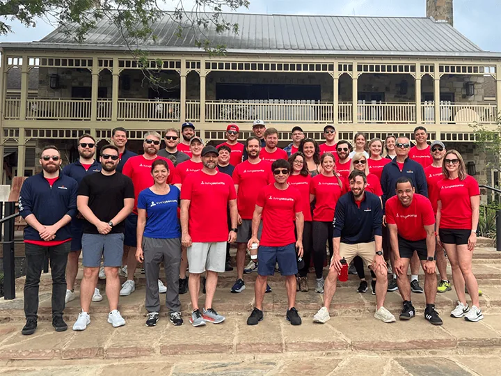 The Living Security team together outdoors in matching red and navy shirts