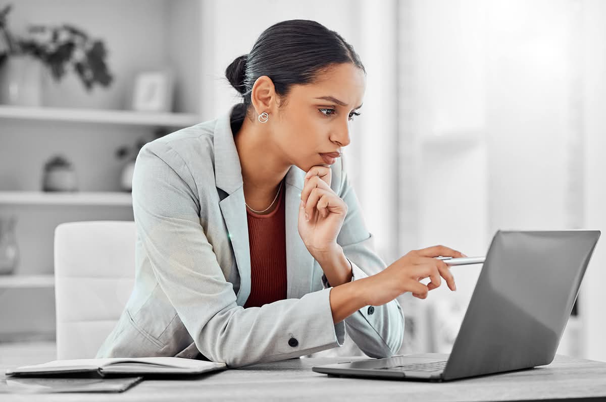 Businesswoman reviewing cybersecurity risks while working on laptop