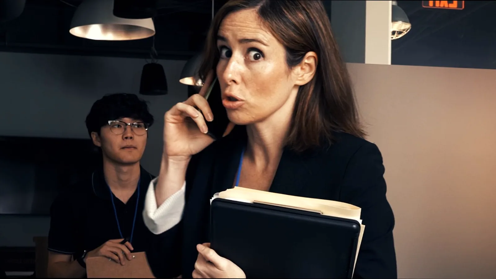 The incident lead takes an urgent call while a colleague waits with his laptop.